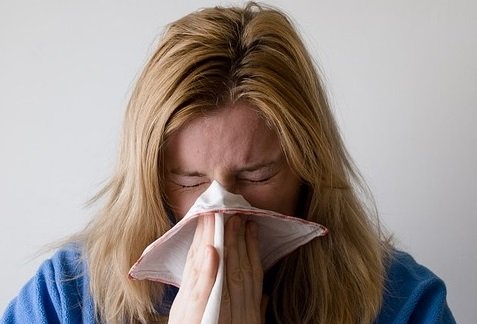 Woman sneezing due to hay fever
