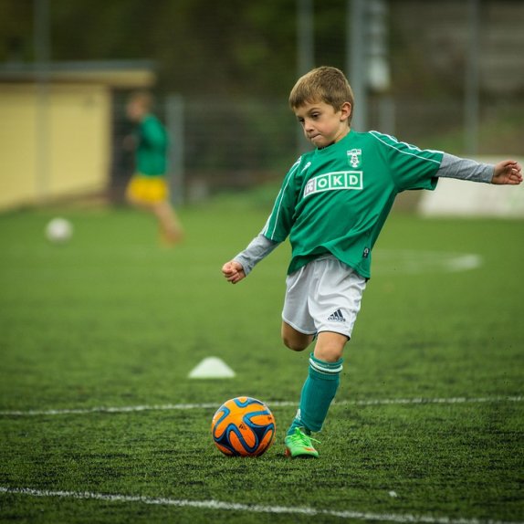 Boy kicking football