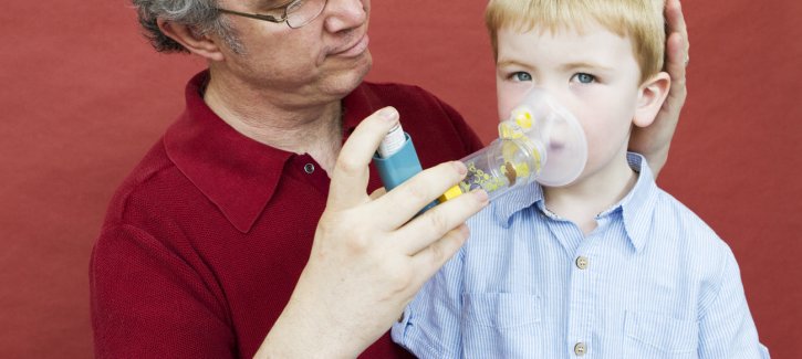 Father helping son with inhaler