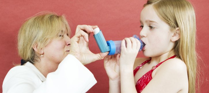 Girl being taught to use inhaler and spacer