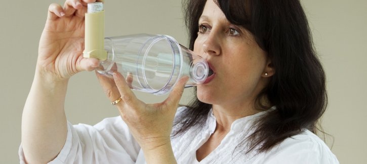 Woman using volumatic chamber and controller inhaler